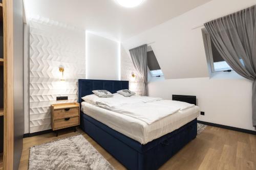 考斯赛力克Mountain Apartments Butorowy Residence的一间设有蓝色床的卧室,位于带窗户的房间内