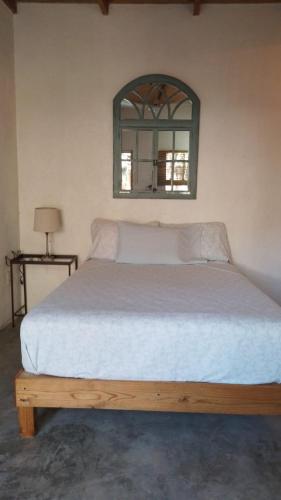 马祖特Casa de Kai Mazunte的卧室配有一张大床,墙上装有镜子