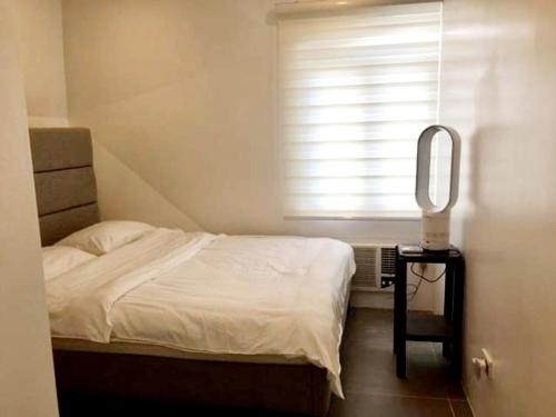 CaloCozy Holiday Home at Batulao Artscapes 2Br brand new fully airconditioned的一间卧室配有一张床、镜子和窗户