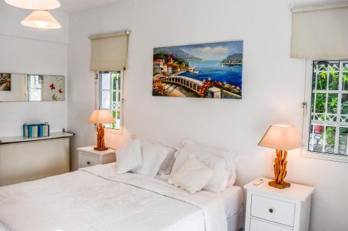 PuntaView Villas的卧室配有白色的床和两盏灯。