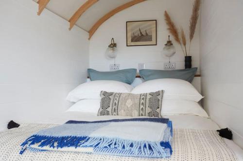赖德The Cabana - a romantic seaside getaway and garden的一间卧室配有两张带白色和蓝色枕头的床