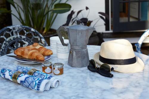 赖德The Cabana - a romantic seaside getaway and garden的一张带帽子的桌子,一些饮料和面包
