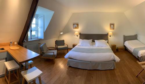 Dragey勒多米尼贝尔维尔酒店的一间卧室配有一张床、一张桌子和一张桌子
