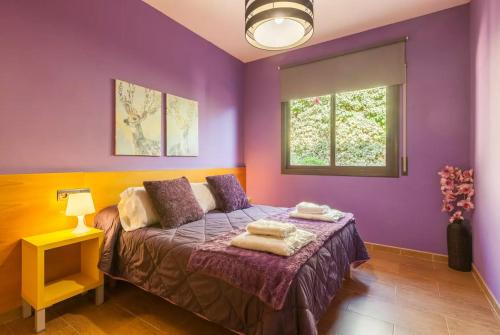 巴塞罗那Casa Lourdes的紫色卧室设有一张床和一个窗户