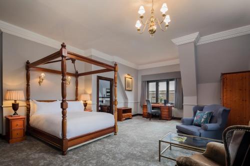 诺里奇Dunston Hall Hotel, Spa & Golf Resort的一间带天蓬床的卧室和一间客厅