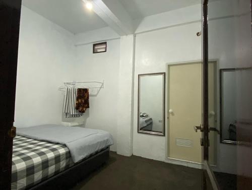 BanjarbaruViolet Doorz Syariah的一间白色的小房间,配有床和镜子