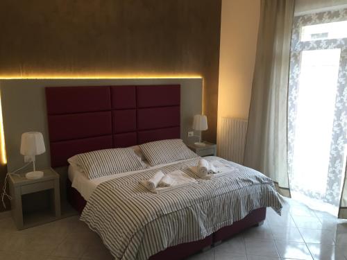 莱切S'Oronzo Modern Town House的一间卧室配有一张大床和红色床头板