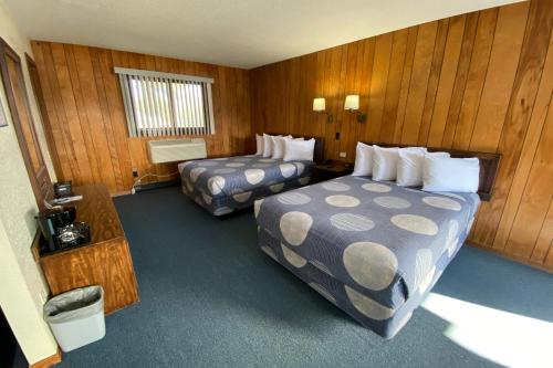 印第安河Waterway Inn的酒店客房,设有两张床和木墙