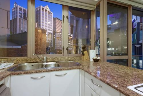 奥克兰CBD Stunner - Skytower View - WIFI - Netflix的一个带水槽和大窗户的厨房