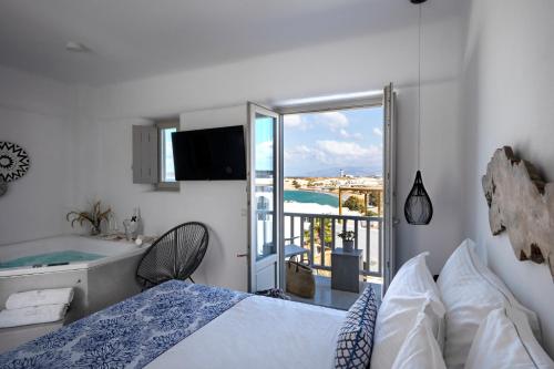 纳乌萨Angels Pillow Luxury Boutique Residence - Adults Only的一间带一张床和一个浴缸的卧室以及一个阳台