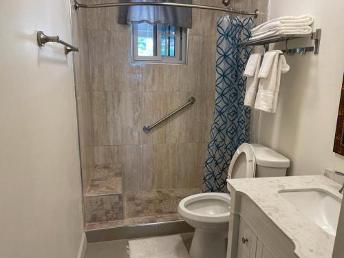 白豪斯Westmore Beach Villas Limited的带淋浴、卫生间和盥洗盆的浴室