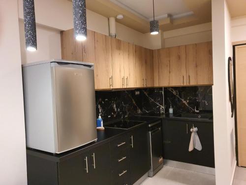 科扎尼Kozani Home 01的厨房配有黑色橱柜和不锈钢冰箱