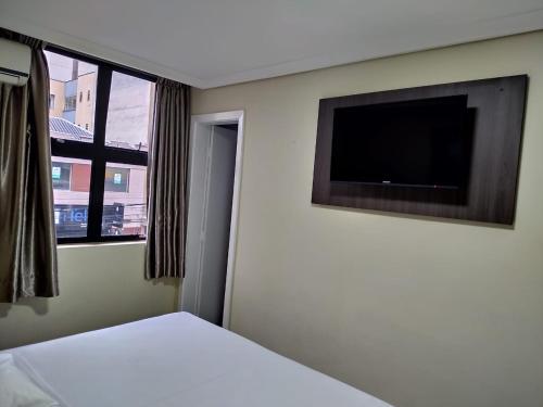 库里提巴爱斯塔克快捷酒店的一间卧室配有一张床和一台平面电视