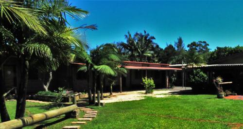 托雷斯Hostel CASA DA PEDRA CHATA的棕榈树庭院和建筑
