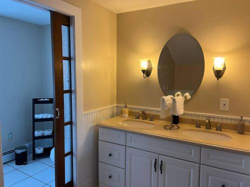 东北Spacious 5 BR Home w/ Hot Tub的一间带两个盥洗盆和大镜子的浴室