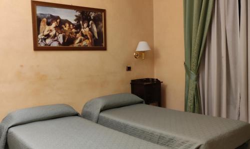 罗马Hotel Montreal Uno的一间设有两张床的客房,墙上挂着一幅画