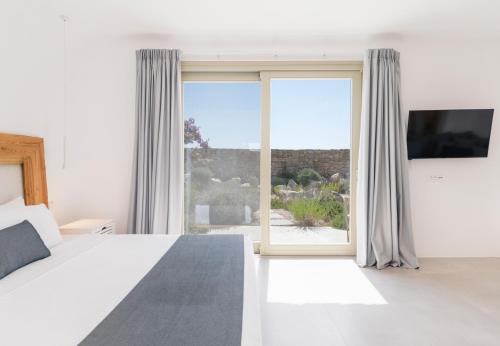 法纳里My Castle House - MG Villas Mykonos的一间卧室设有一张床和一个大窗户