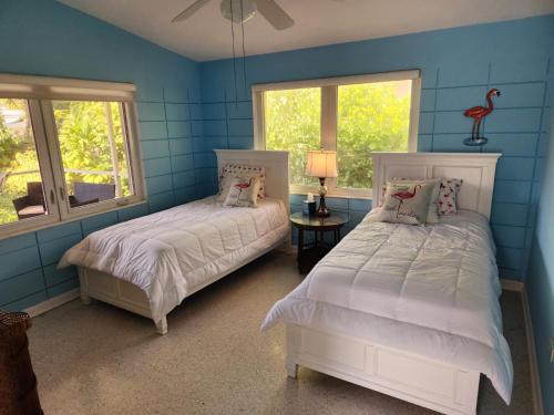 马拉松The Butterfly Cottage的配有两张床铺的蓝色墙壁和窗户