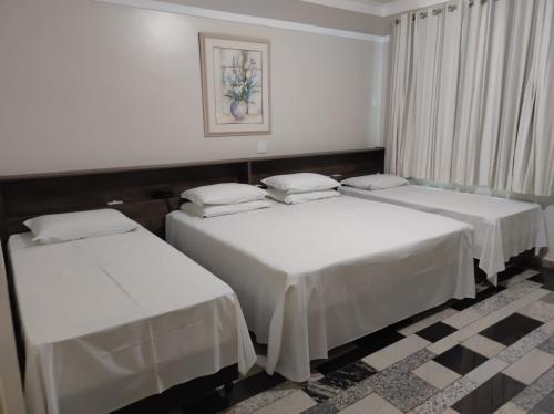 ArapongasLodi Express Hotel的配有白色床单的客房内的两张床