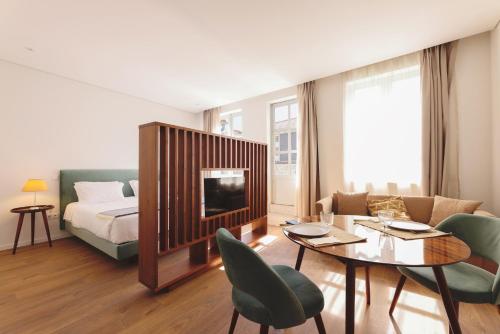 波尔图RIBEIRA FLORES 59 Downtown Apartments的客厅配有床和桌椅