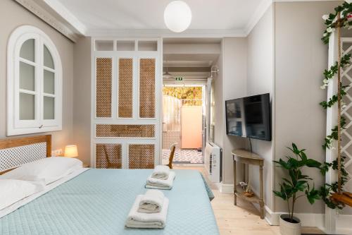 AnemómylosWell Apartments by Skyloft Corfu的一间位于蓝色楼层的卧室,配有一张带两条毛巾的床