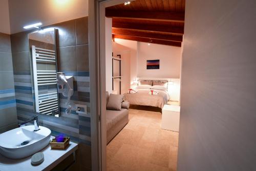 奥托纳IL CAMBUSIERE nature relais的一间带水槽的浴室和一间带一张床的卧室