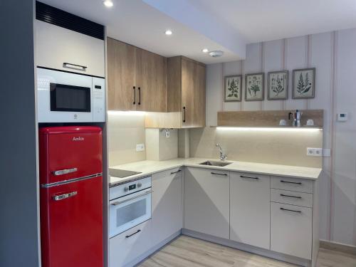 毕斯卡斯卡萨尔萨巴拉公寓酒店的厨房配有红色冰箱和白色橱柜