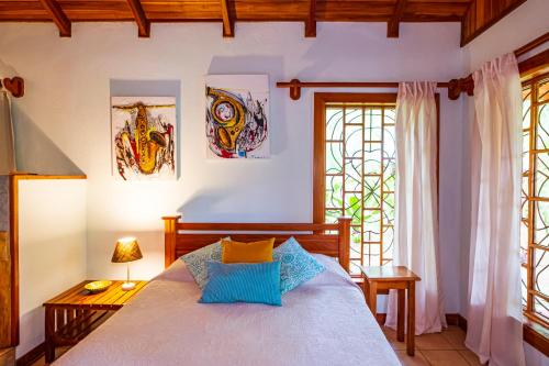 别霍港El Nido Jungle Lodge的一间卧室设有一张床和两个窗户。