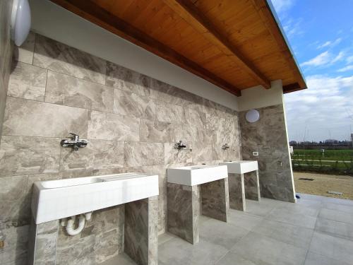 Pacengo di LaziseAgricamping Corte Pianton的浴室设有石墙和2个水槽。
