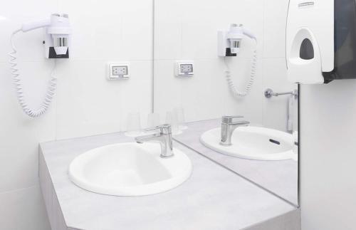 塔拉拉塔拉安迪娜标准酒店的白色的浴室设有两个盥洗盆和镜子