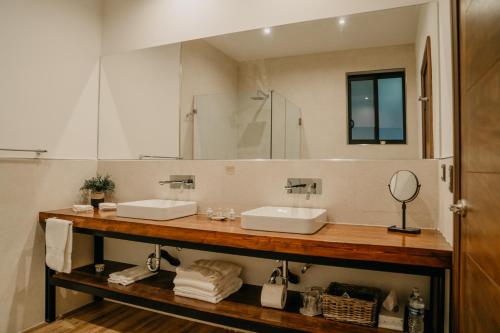 瓜达鲁佩镇Villa Montefiori的一间带两个盥洗盆和大镜子的浴室