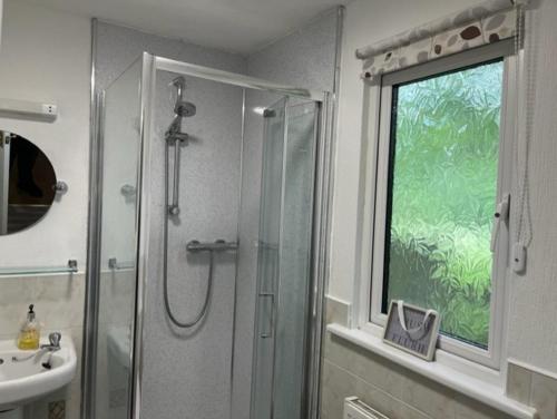 布莱克浦Family Holidays Blackpool的带淋浴和盥洗盆的浴室以及窗户。