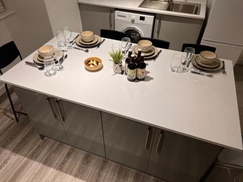 北安普敦Superb modern flat in Northampton, parking &EV的厨房岛配有玻璃杯和葡萄酒瓶