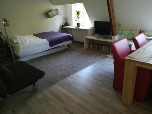 奈梅亨德格菲特住宿加早餐旅馆的卧室配有一张床和一张桌子及椅子