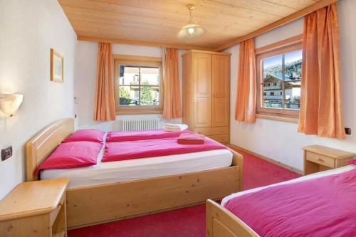 利维尼奥Appartamenti Bait da Erich的一间卧室设有两张床和两个窗户。