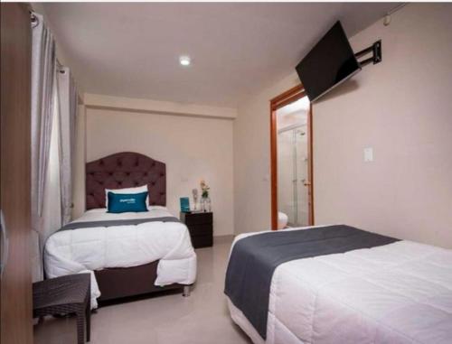 库斯科Hotel Luna de Oro Cusco的一间卧室设有两张床和窗户。