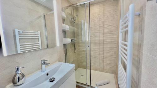 芒通« LA SUITE »Superbe appartement NEUF, Front de mer的一间带水槽和玻璃淋浴的浴室