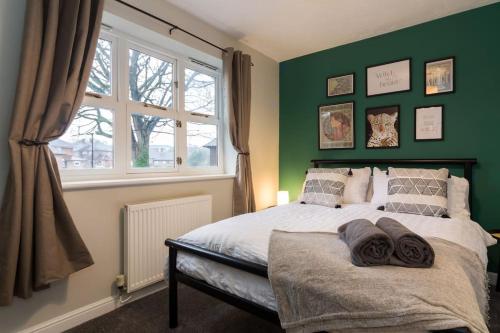 谢菲尔德Stylish two bedroom home SHEFFIELD的一间卧室设有一张带绿色墙壁和窗户的床。