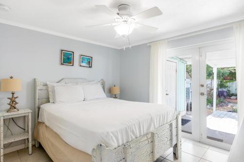 基克罗尼海滩KCB Bungalow的白色的卧室设有床和窗户