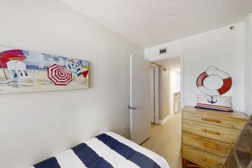 默特尔比奇The Pinnacle 601的卧室配有一张床,墙上挂有绘画作品