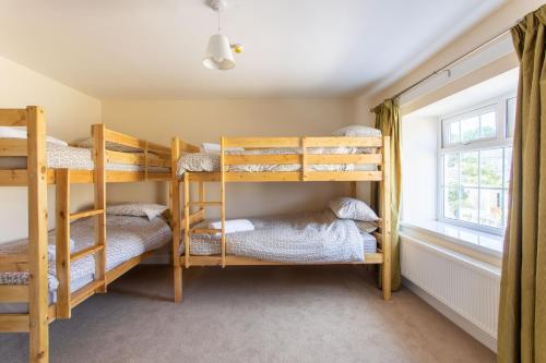 AbercanaidBikehaus@The Colliers Arms的一间带双层床的卧室,位于带窗户的房间内