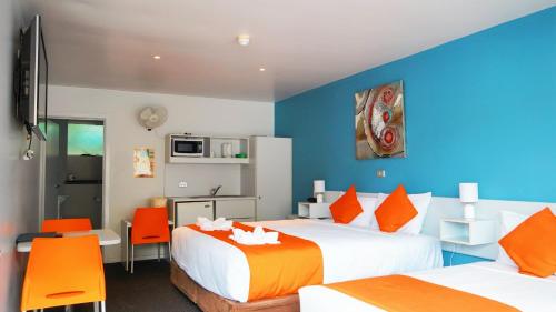 霍巴特海滨洛奇汽车旅馆的酒店客房,配有两张床和橙色椅子