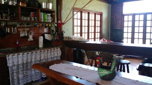 多明戈斯马丁斯Pousada Sítio Rústicu's的厨房配有柜台和桌椅