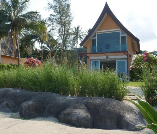 象岛维生素海别墅的海滩上的房子,前方有雕像