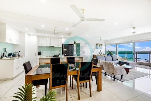 达尔文ZEN BY THE WATER - Darwin's Premier Ocean View Family Retreat的厨房以及带桌椅的起居室。