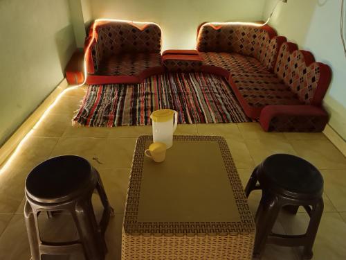 达哈布Private room in Dahab,10 minutes to sea的客厅配有咖啡桌和2张凳子