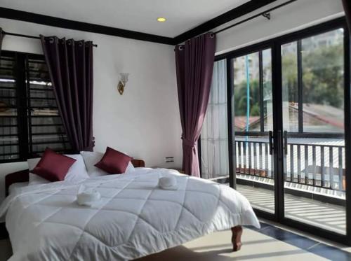 西哈努克Paradise Cozy Guesthouse Sihanoukville的一间带白色床的卧室和一个阳台