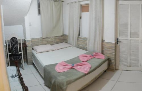 马卡埃Pousada nascente do sol的一间卧室配有两张带弓的床铺