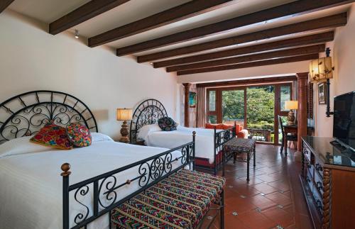帕纳哈切尔阿迪特兰酒店的一间带两张床的卧室和一间客厅