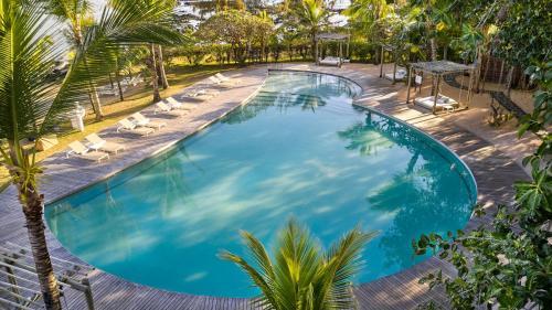 格兰高伯LUX* Grand Gaube Resort & Villas的享有带躺椅和棕榈树的游泳池的顶部景致